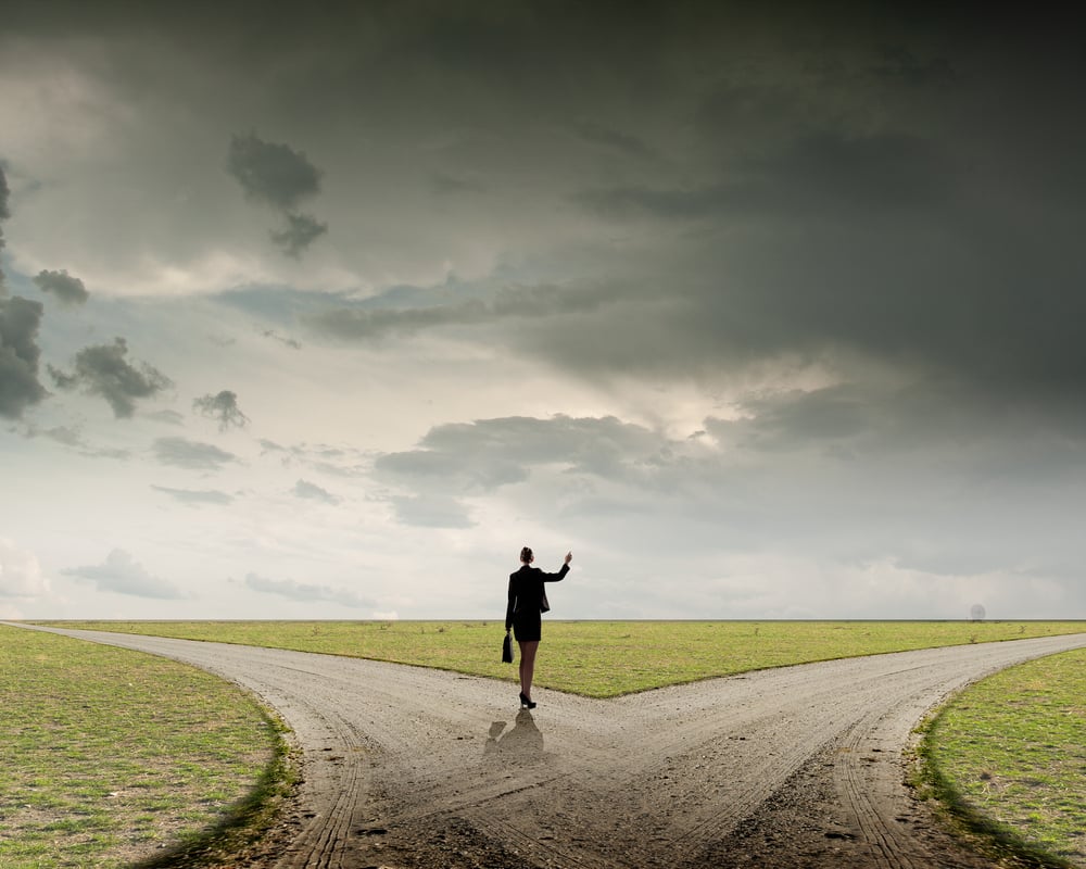 Back view of businesswoman standing on crossroads and making choice