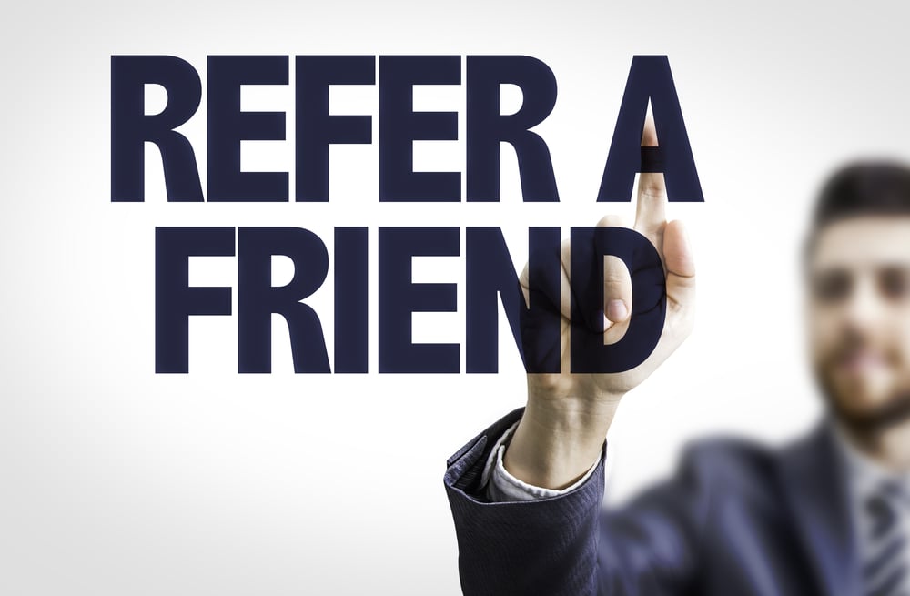 Business man pointing the text Refer a Friend