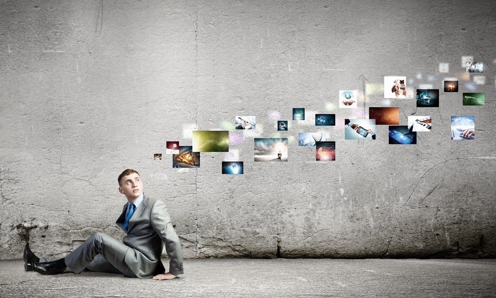 Image of young man sitting on floor looking on media icons