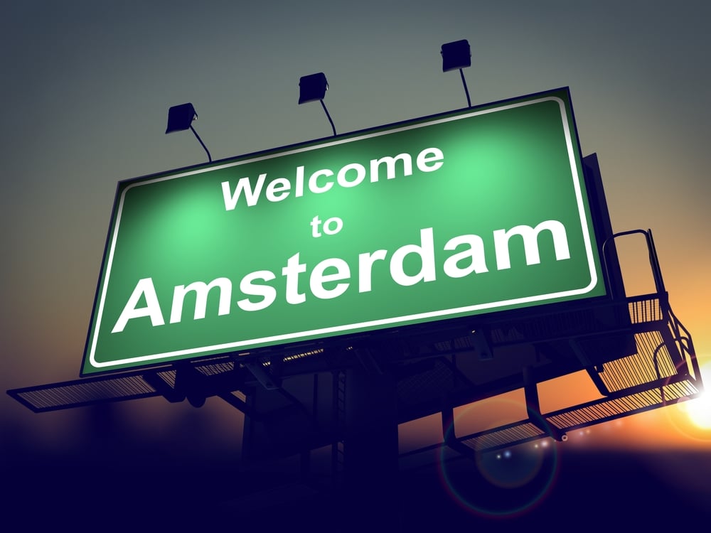 Welcome to Amsterdam - Green Billboard on the Rising Sun Background.